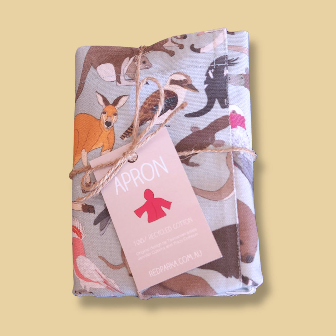 Folded apron with animal pattern and 'APRON' tag on a yellow background