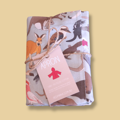Folded apron with animal pattern and 'APRON' tag on a yellow background