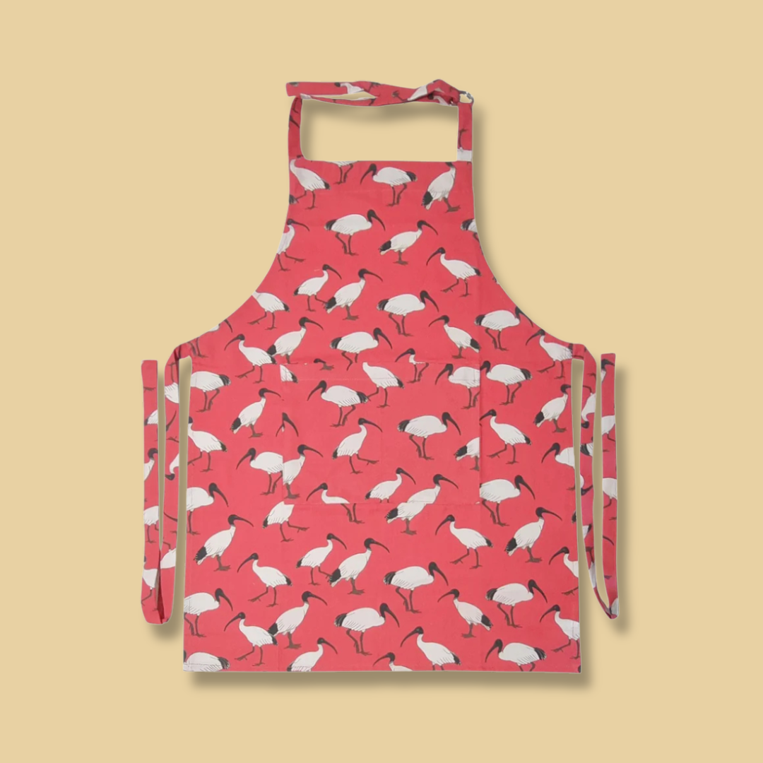 Red apron with an Ibis bird pattern on a yellow background